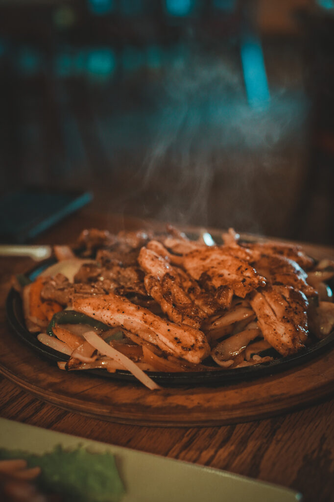 Plate of chicken fajitas with steam rising from the food